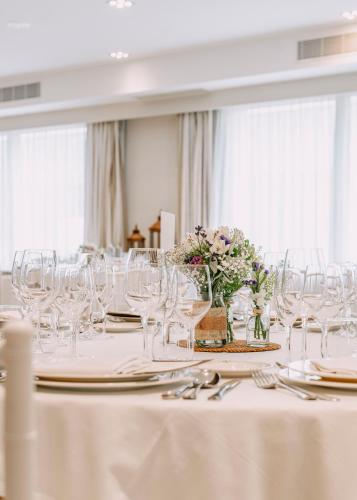 a table with wine glasses and flowers in a mirror at Vincci Resort Costa Golf in Chiclana de la Frontera