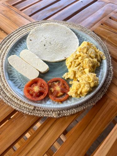 a plate with scrambled eggs and tomatoes and a tortilla at Thani Ecobeach Barú in Playa Blanca