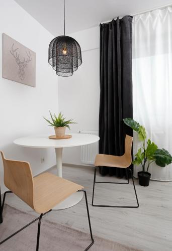a dining room with a white table and two chairs at Modern & Cozy Studio with Balcony in Roşu