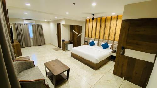 Mezkar Residency في Alwaye: غرفة في الفندق بسرير ومكتب وطاولة