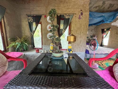a living room with a glass table and two chairs at Clay House Chiang Mai By Alphatel in Chiang Mai