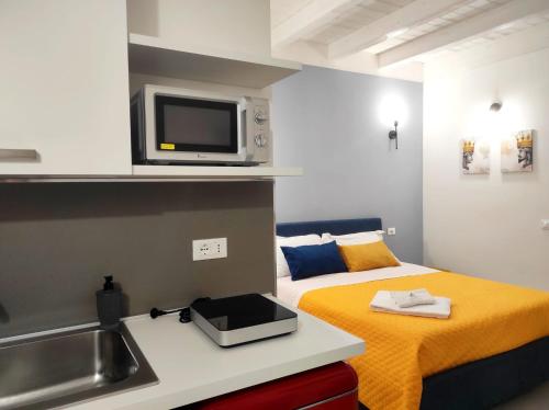 a small kitchen with a bed and a microwave at White Wall luxury rooms Scala dei turchi in Realmonte