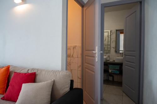 a living room with a couch and a bathroom at Résidence ATLAS in Saint-Laurent du Maroni
