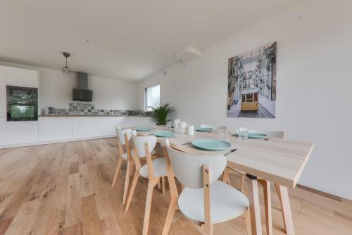 une salle à manger avec une table et des chaises en bois dans l'établissement Maison pour 8 - 300m de la plage du Rouvran, à Le Tour-du-Parc
