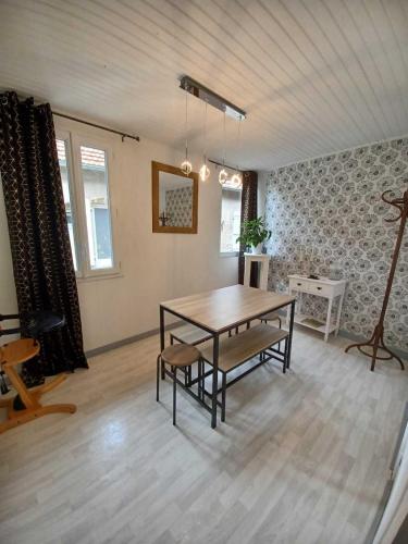 une salle à manger avec une table et des chaises dans une pièce dans l'établissement Logis des Pivoines, à Trézelles