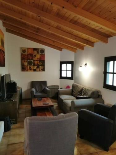 - un salon avec des canapés, une table et des fenêtres dans l'établissement Maison de Vacances Rayons de soleil, à Notre-Dame-de-Monts