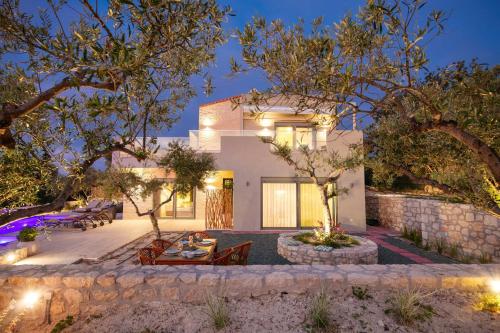 a home with a patio at night at LILY'S VILLA LEMONIA in Platanes