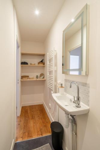 une salle de bain avec un lavabo et un miroir dans l'établissement T2 cosy à deux pas de la gare, à Nantes