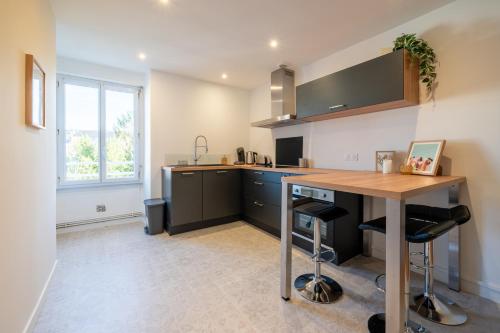 une cuisine avec une table en bois et un comptoir dans l'établissement T2 cosy à deux pas de la gare, à Nantes
