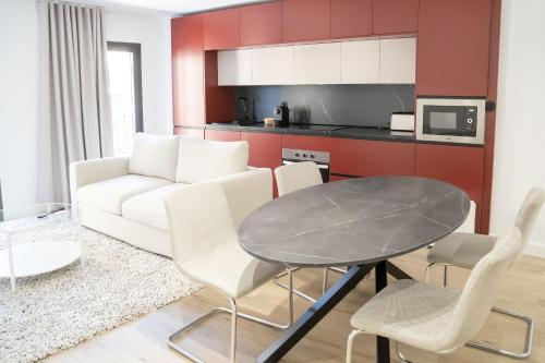 a living room with a white couch and a table at Apartamentos MLC Ciudad de Linares in Linares