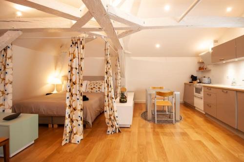 une chambre avec un lit et une table et une cuisine dans l'établissement Apt loft luxueux et design, à Eymet