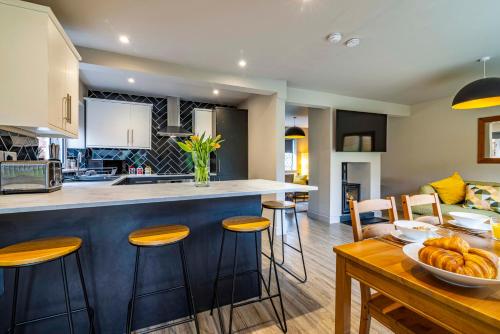 a kitchen and living room with a counter and stools at Modern home - great facilities-J26 M1 near IKEA in Nottingham