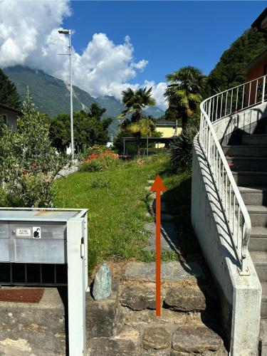 a stairway with an orange arrow next to a building at Appartamento C5 in Arbedo-Castione