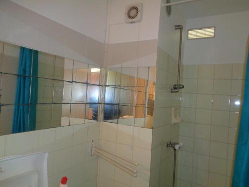 une salle de bain avec une douche avec une porte vitrée dans l'établissement studio location saisonnières a la grande motte, à La Grande Motte