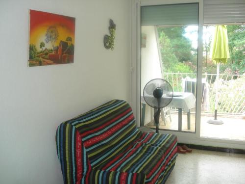 un salon avec une chaise et une fenêtre dans l'établissement studio location saisonnières a la grande motte, à La Grande Motte