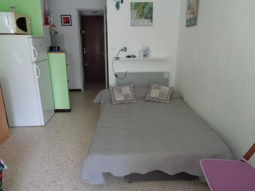 Cette petite chambre comprend un lit et un réfrigérateur. dans l'établissement studio location saisonnières a la grande motte, à La Grande Motte