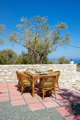 a wooden table and chairs on a patio at LILY'S VILLA LEMONIA in Platanes