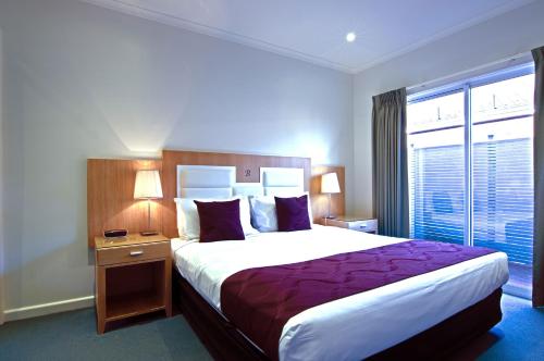 a hotel room with a large bed and a window at Brighton Serviced Apartments in Melbourne