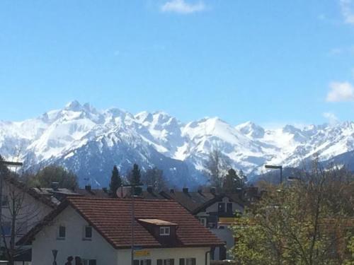 a town with snow covered mountains in the background at Ferienwohnung Wölk in Sonthofen
