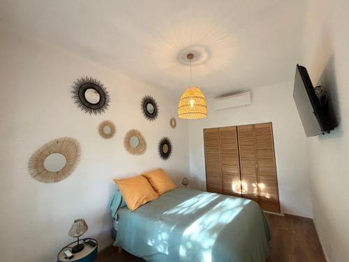 a bedroom with a bed and a television and mirrors at Appartement eygalieres avec petit jardin in Eygalières