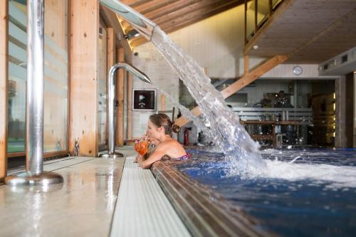 a young boy is playing in a swimming pool at Bivio Hotel Plaza in Livigno