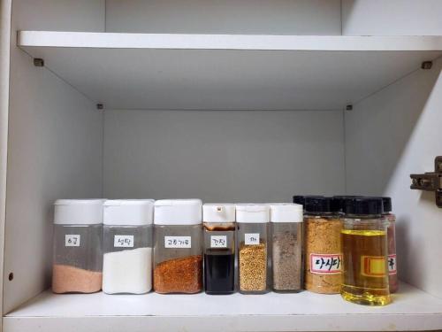 a shelf with jars of spices on it at Seeun house in Gwangju