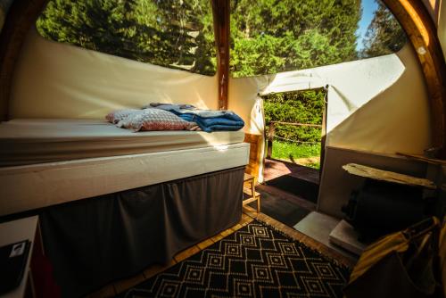 - une tente avec un lit à l'intérieur dans l'établissement Eco Bivouac village igloos Annecy - LE SEMNOZ - à 20 minutes d'Annecy, à Annecy