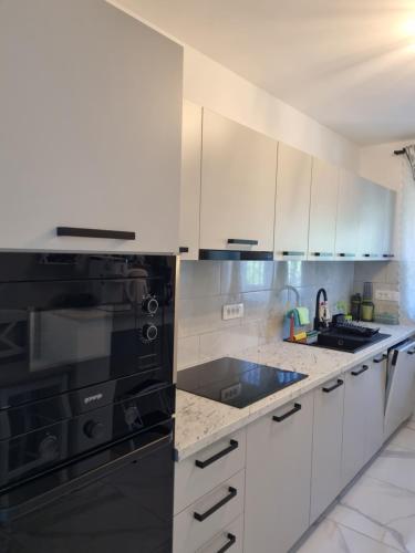 a kitchen with white cabinets and black appliances at Bruno 1 in Senj
