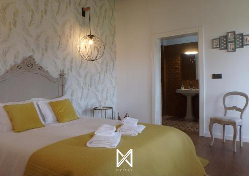 a bedroom with a bed with towels on it at MyStay - Casa de Tent'tugal in Montemor-o-Velho