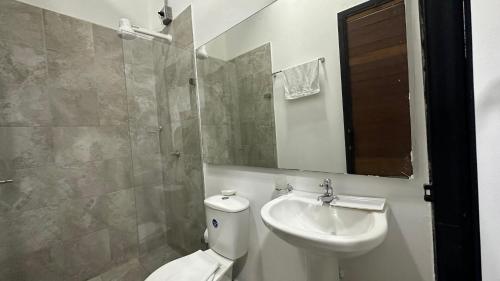 a bathroom with a sink and a toilet and a mirror at Malibu loft hotel in Medellín
