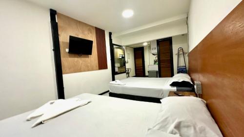a hotel room with two beds and a mirror at Malibu loft hotel in Medellín