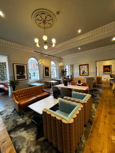 a hotel lobby with couches and tables and a chandelier at The Queen at Chester Hotel, BW Premier Collection in Chester