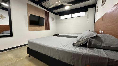 a bedroom with two beds and a flat screen tv at Malibu loft hotel in Medellín