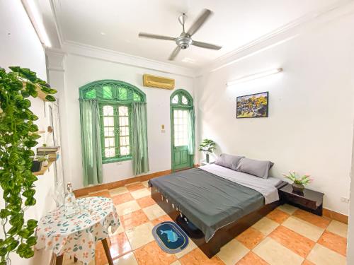 een slaapkamer met een bed en een plafondventilator bij Morri Homestay - Quán Thánh in Hanoi