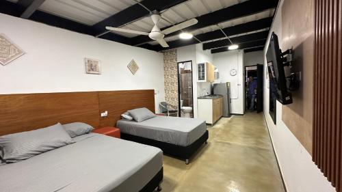 a bedroom with two beds and a tv in it at Malibu loft hotel in Medellín