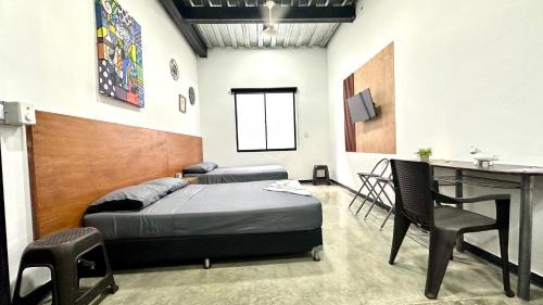 a bedroom with a bed and a desk and a table at Malibu loft hotel in Medellín