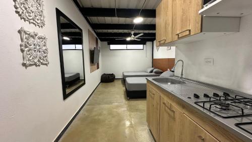 a kitchen with a sink and a couch in a room at Malibu loft hotel in Medellín