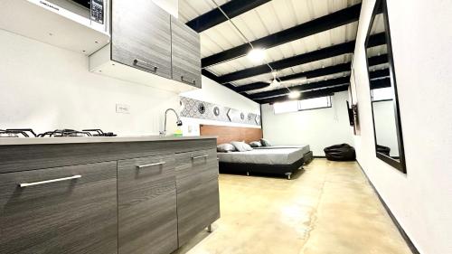 a kitchen with a sink and a couch in a room at Malibu loft hotel in Medellín