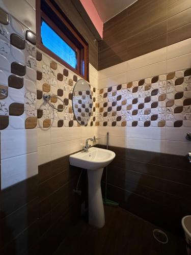 a bathroom with a sink and a mirror at Pahadirovers Homestay & Cafe in Kasol