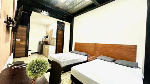 a room with two beds and a table and a kitchen at Malibu loft hotel in Medellín