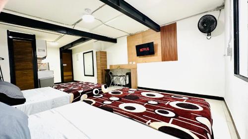 a bedroom with two beds with a comforter on it at Malibu loft hotel in Medellín