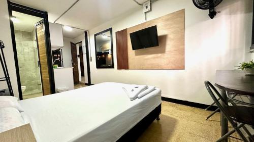 a bedroom with a bed and a tv on the wall at Malibu loft hotel in Medellín