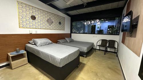 a bedroom with two beds and a table and two chairs at Malibu loft hotel in Medellín