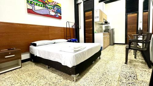a bedroom with a bed and a table and a chair at Malibu loft hotel in Medellín