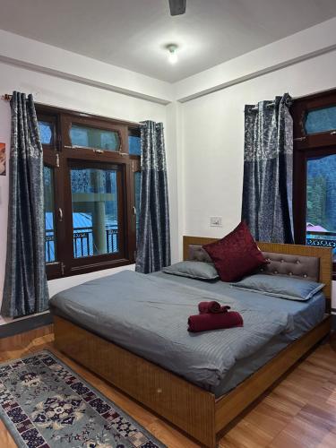 a bedroom with a bed with two red shoes on it at Pahadirovers Homestay & Cafe in Kasol