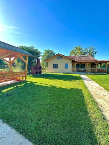 a large yard with a house and a wooden pavilion at Casa Phoenix in Uzlina