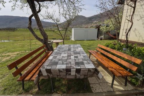 a wooden bench and a table in a yard at Camp Tommy in Jaklići