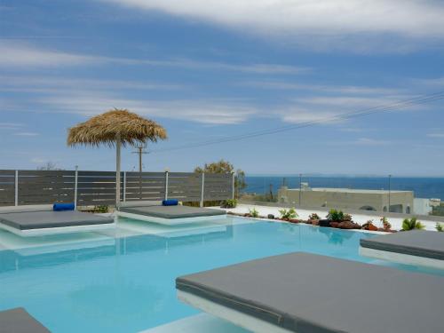 a swimming pool with a view of the ocean at Nalu Suites in Fira
