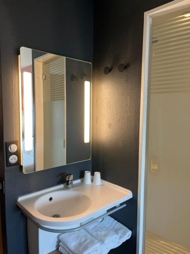 een badkamer met een wastafel en een spiegel bij B&B HOTEL Liège Rocourt in Luik
