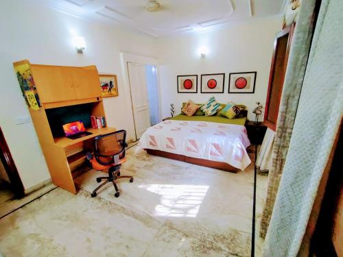 ニューデリーにあるLutyen's Delhi Neighbourhood Prime Stayのベッドと机と椅子のある寝室